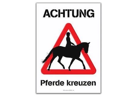 Ein Schild mit Turnier | Achtung Pferde kreuzen drauf.