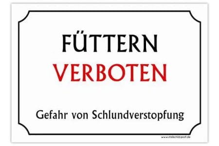 Eine Stallschild-Stalltafel „Füttern verboten – Schlundverstopfung“, auf der auf Deutsch „futtern verboten“ steht.